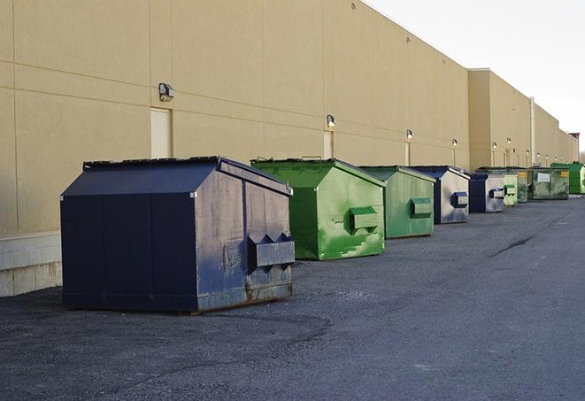 a group of dumpsters lined up along the street ready for use in a large-scale construction project in Fort Pierce